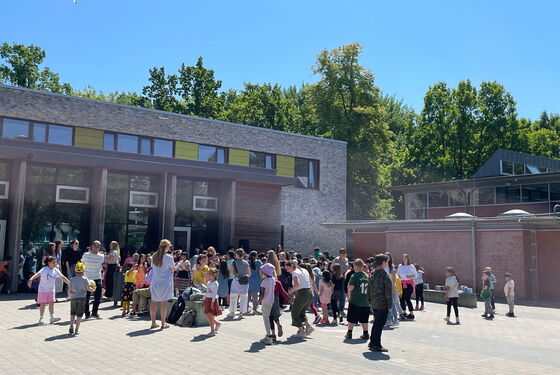 Schülerinnen und Schüler feiern und tanzen auf dem Schulhof