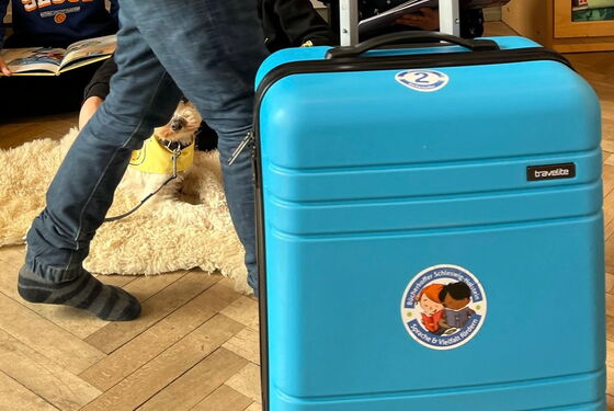 Schüler schiebt Bücherkoffer ins Klassenzimmer