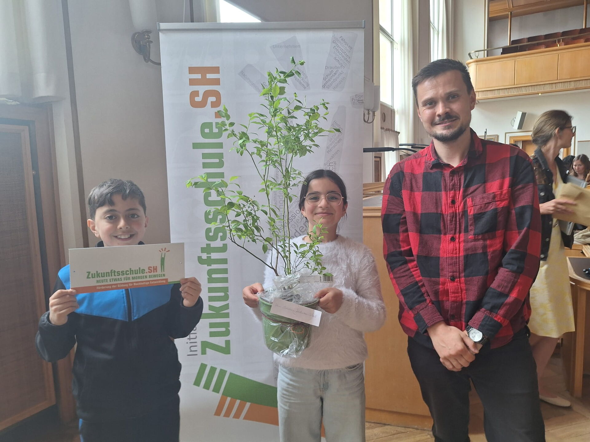 Schülerin und Schüler mit Lehrer Herrn Toschke halten Auszeichnung hoch