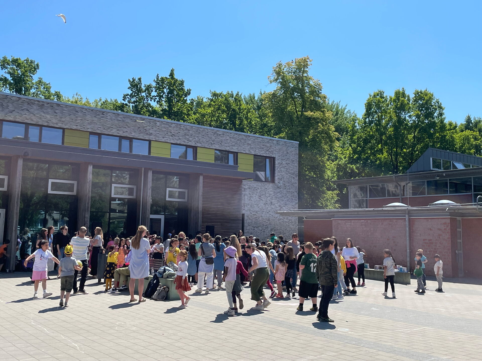 Schülerinnen und Schüler feiern und tanzen auf dem Schulhof